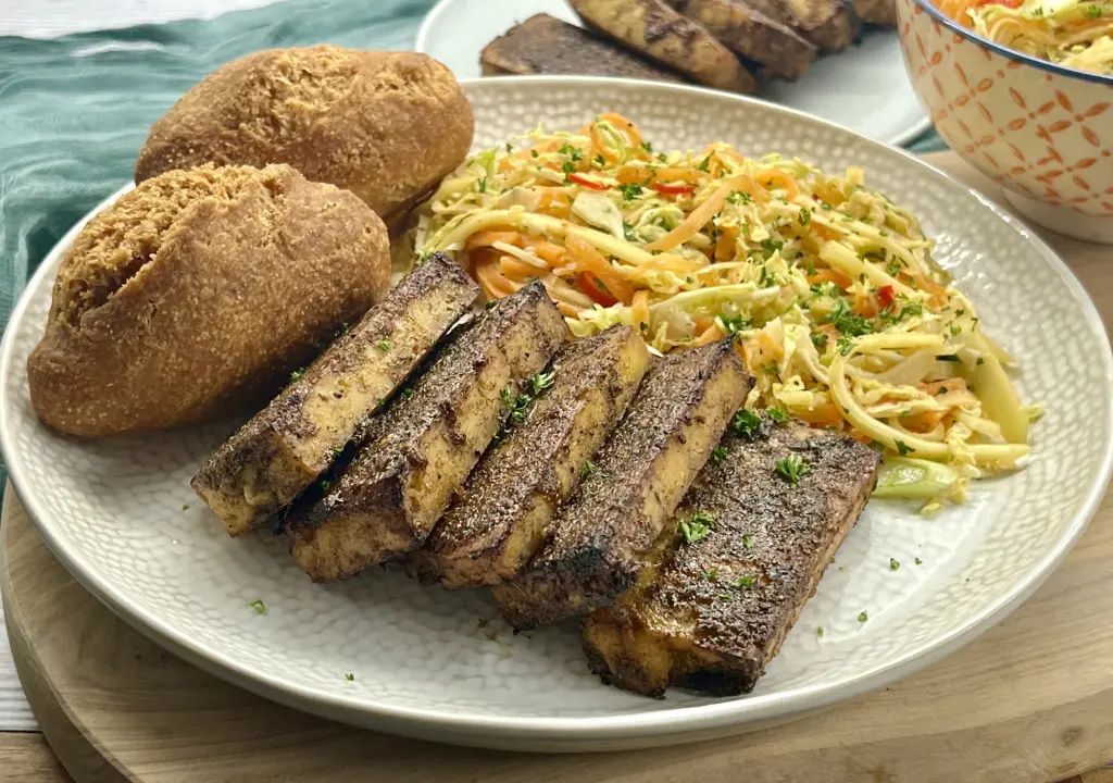 Jerk Tofu with Festival - Marinated jerk tofu served with traditional Jamaican festival bread